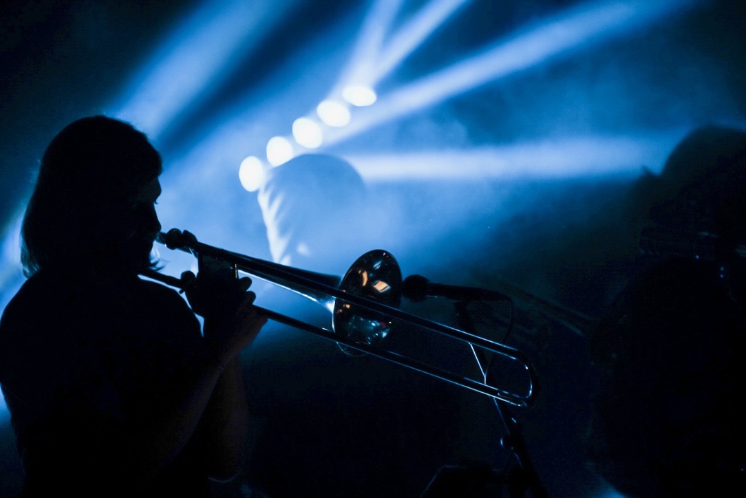 a silhouette of a man playing a trombone